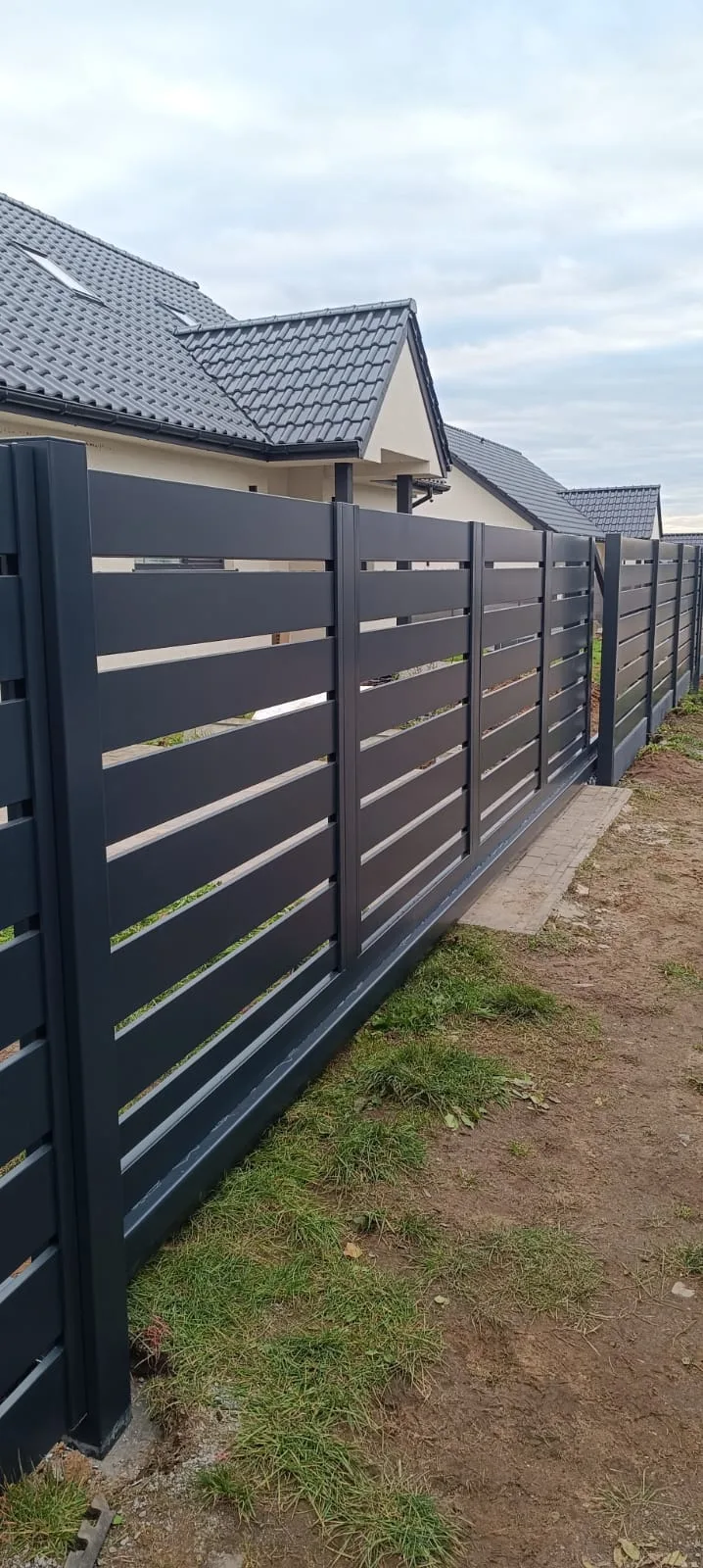 Ogrodzenia metalowe z poziomymi czarnymi belkami, nowoczesny design przy posesji