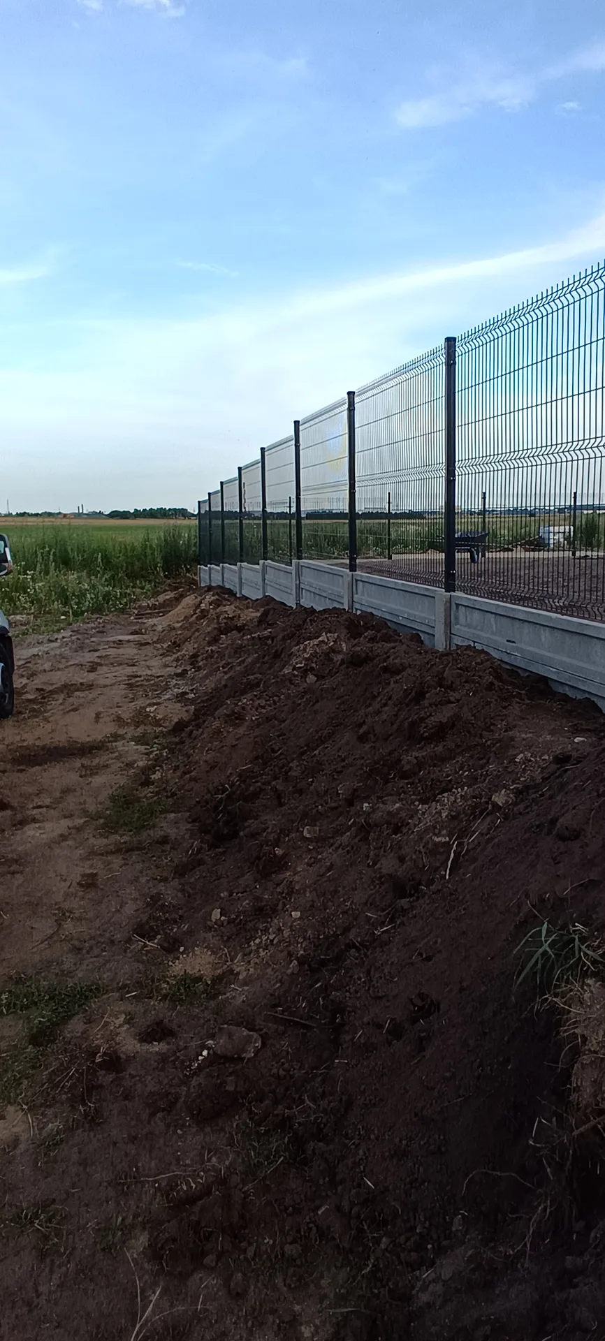 Ogrodzenia siatkowe - montaż z białymi panelami dolnymi i słupkami metalowymi
